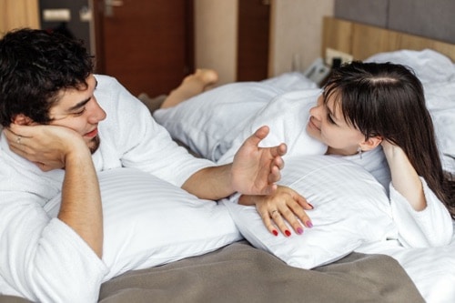 Ein Paar praktiziert aktives zuhören im Bett